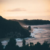 an ocean sprayed, shoreline hill at dusk